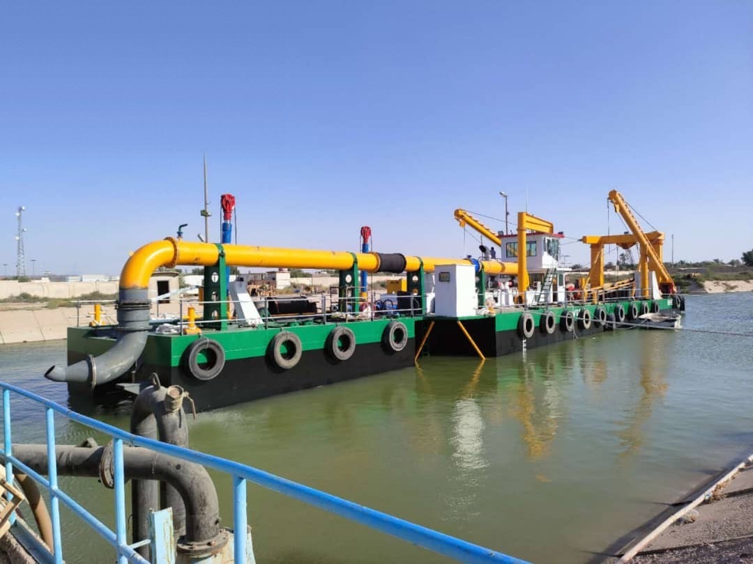 Cutter suction dredger with floating discharge pipeline during a channel dredging campaign