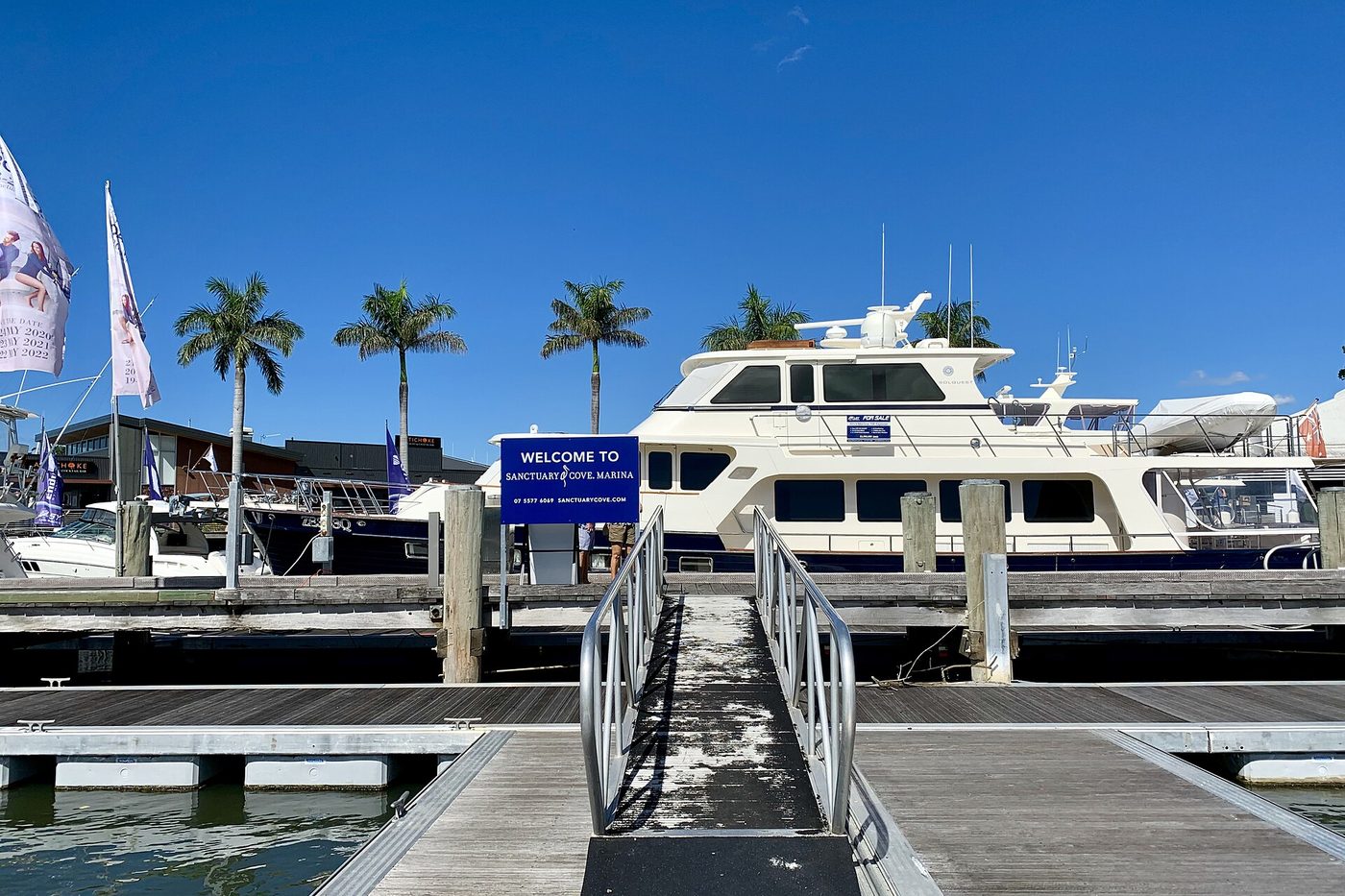 Marina gangway and floating berth arm with a motor yacht alongside