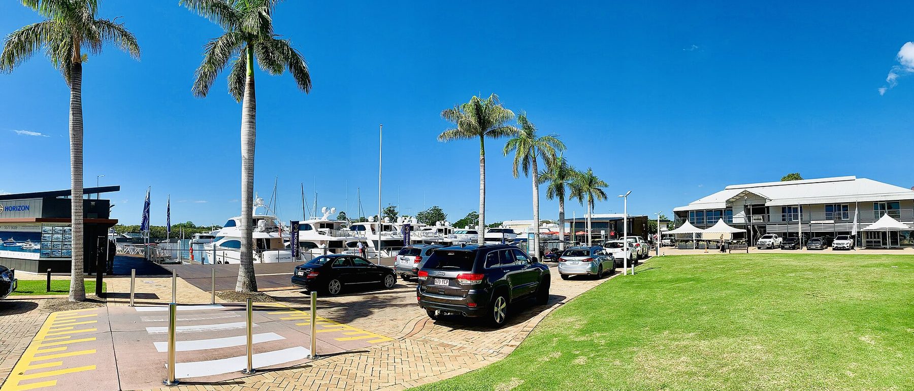 Marina precinct with berth arms, palms and waterfront buildings at Sanctuary Cove, Queensland